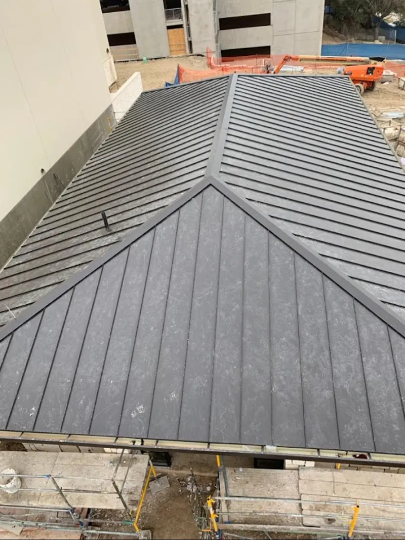 Commercial metal roof construction with crane equipment in Bowie